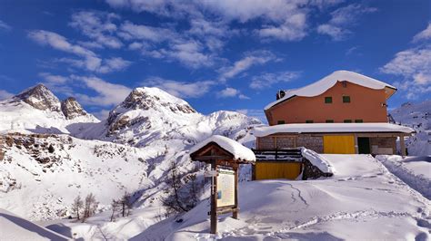 Vista del Rifugio Calvi immerso nel paesaggio montano innevato.