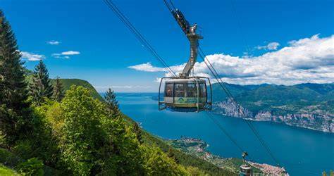 Vista panoramica del Lago di Garda dall'alto, con le cabine della funivia in primo piano