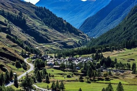 Vista panoramica della valle Varaita con montagne innevate e un villaggio tradizionale.