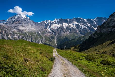 Vista aerea di un quad che percorre un sentiero sterrato su una montagna, con un paesaggio panoramico sullo sfondo.