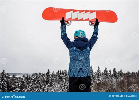 Bambino sorridente con snowboard su una pista innevata