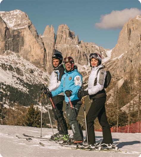 Maestri di sci che insegnano a un gruppo di bambini su una pista innevata in Alta Badia