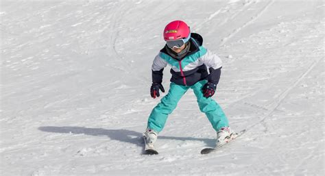 Un rider esegue una curva stretta e aggressiva in carving su una pista innevata.