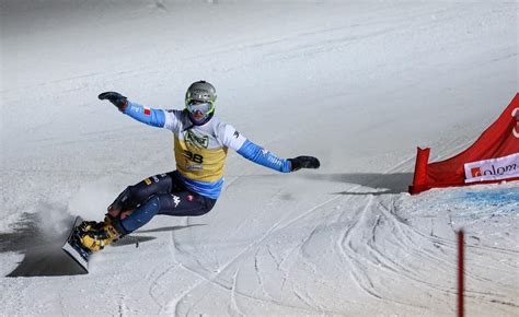 Snowboarder in posizione di carving estremo, con il corpo quasi parallelo alla neve.