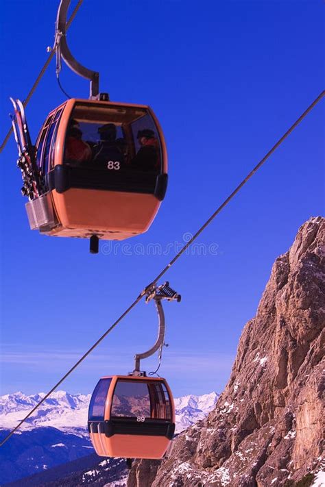 immagine di una moderna funivia di montagna in movimento, con cabine piene di sciatori