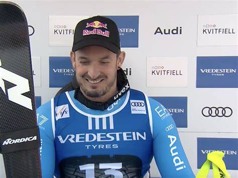 Dominik Paris che festeggia una vittoria con la bandiera italiana