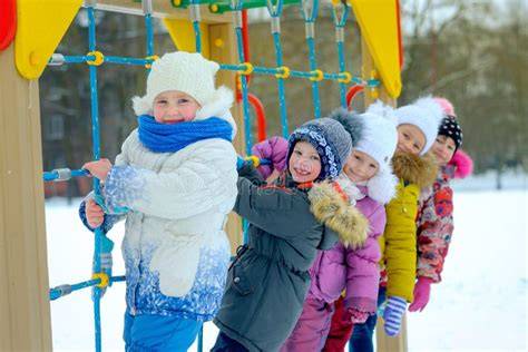 Bambini che giocano in un'area giochi invernale attrezzata