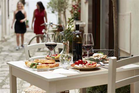 Tavola imbandita con specialità italiane e biciclette sullo sfondo