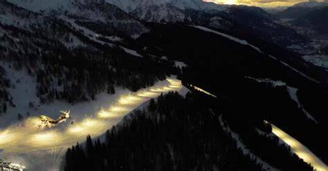 vista notturna di una pista da sci illuminata per una gara