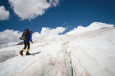 Alpinista che attraversa un ghiacciaio con ramponi classici.