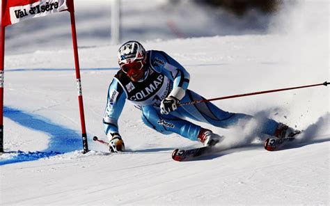 Sciatore che esegue una curva in neve fresca in montagna