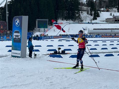 Panoramica della pista di biathlon innevata con atleti in gara.
