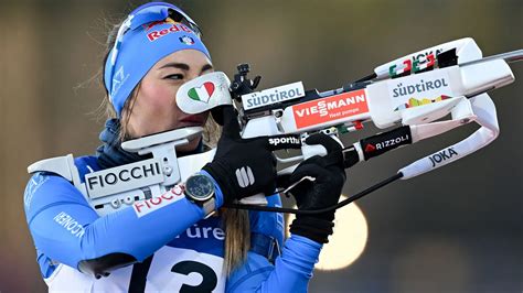 Primo piano di un atleta di biathlon al poligono di tiro.