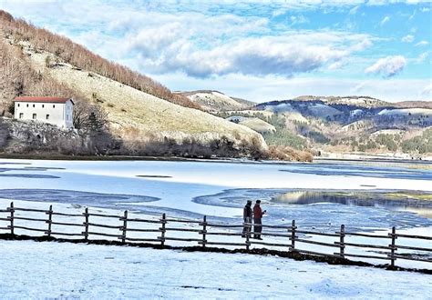 Panoramica del Lago Laceno con montagne innevate e attività ricreative