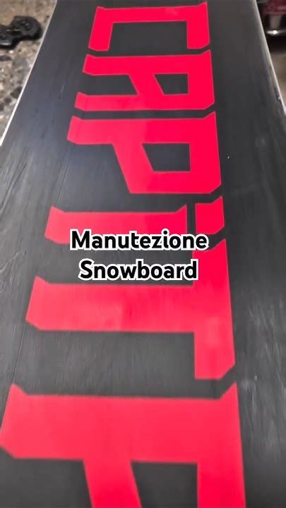 Primo piano delle lamine di uno snowboard, che mostrano segni di usura.