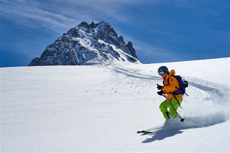 Panorama alpino con neve fresca e montagne rocciose, ideale per lo scialpinismo