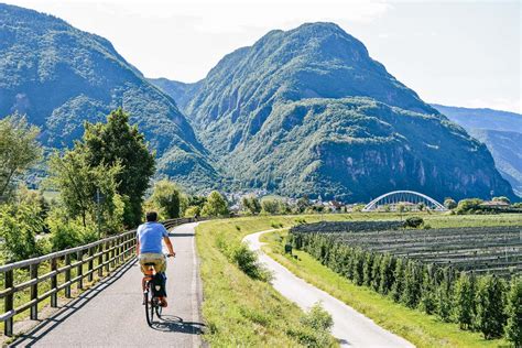 Ciclabile lungo l'Adige con montagne sullo sfondo