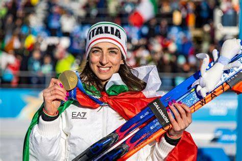 Foto di Lisa Vittozzi che festeggia la vittoria sul podio, con le bandiere italiana e dei paesi delle altre atlete premiate.
