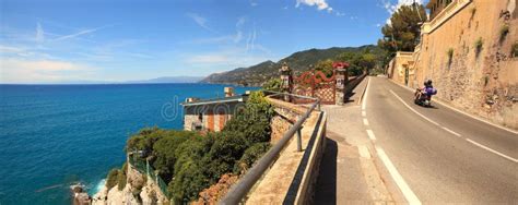 Ciclisti che pedalano lungo la strada panoramica con vista sul mare blu intenso