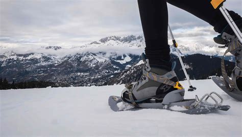 Coppia che utilizza le ciaspole su un sentiero innevato in montagna