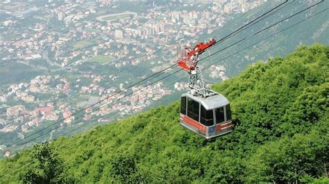 vista panoramica delle Alpi Marittime con una funivia a va e vieni in primo piano