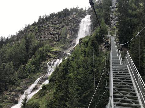 Ponte sospeso che conduce a una piccola cascata circondata da rocce