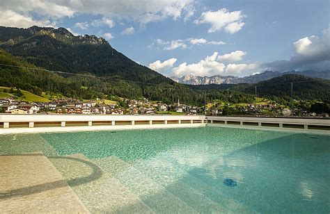 Vista panoramica delle Dolomiti con un hotel dotato di piscina in primo piano