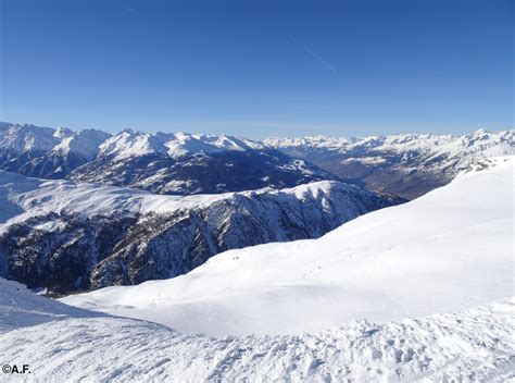 Vista panoramica dalla vetta dello Spitzhorli con cime alpine innevate all'orizzonte.