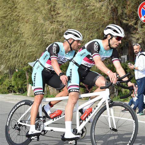 Immagine di un atleta che effettua la transizione tra la frazione ciclistica e quella podistica in una gara di triathlon.