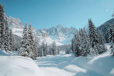 Persona che utilizza una splitboard in un paesaggio montano innevato