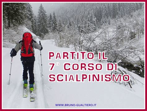 Istruttori di sci alpinismo con i loro allievi in montagna, con le cime innevate sullo sfondo.