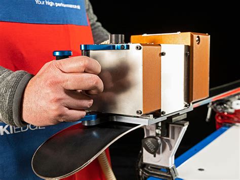Tecnico specializzato mentre affila le lamine di uno sci nel laboratorio