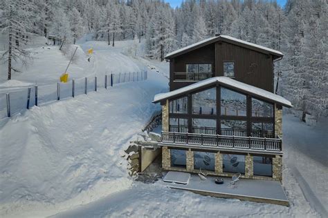 Vista esterna dello Chalet Abete Rosso immerso nella neve e circondato da abeti
