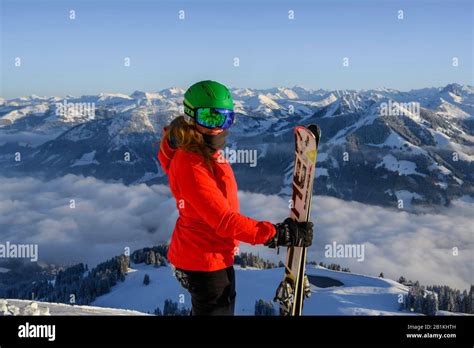Sciatore con maschera da sci che guarda il panorama montano innevato