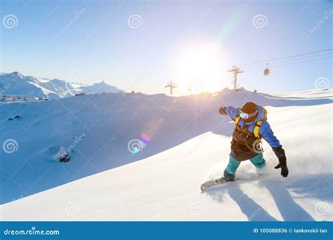 Snowboarder che scende su un pendio innevato in un paesaggio montano.
