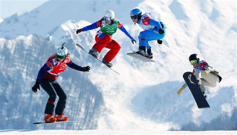 Gruppo di snowboarder che gareggiano contemporaneamente in una gara di snowboard cross.