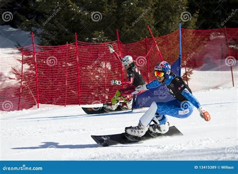 Due snowboarder che gareggiano fianco a fianco su tracciati paralleli nello Slalom Gigante Parallelo.