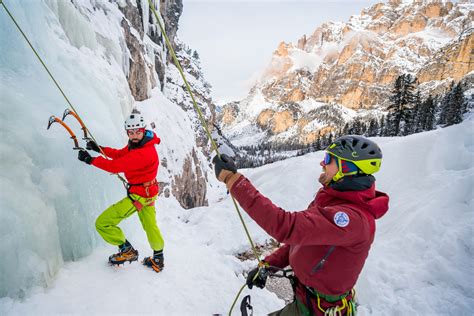 Due atleti di arrampicata su ghiaccio in gara nella disciplina Speed, uno accanto all'altro su una parete verticale.