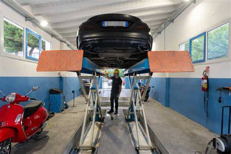 Un'auto su un ponte elevatore durante un controllo di revisione