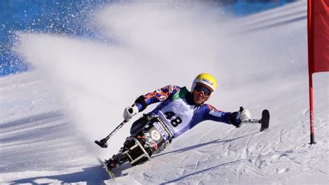 Uno sciatore utilizza un monosci con stabilizzatori per mantenere l'equilibrio sulla neve.