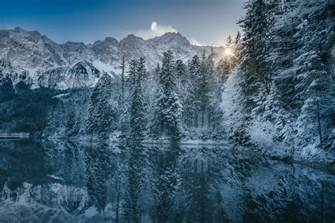 Lago Grosser Arbersee circondato da boschi e montagne innevate.