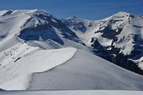 Sci alpinisti che salgono su un crinale innevato con vista sulle montagne.