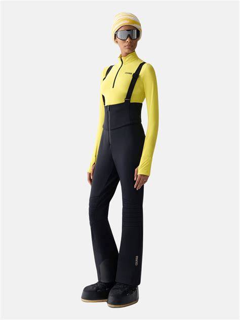 Donna che sceglie tra pantaloni da sci e salopette
