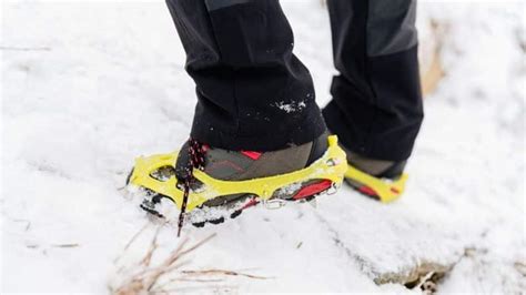 Primo piano di un paio di ramponcini antiscivolo indossati su una scarpa da trekking