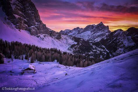 Vista panoramica delle Dolomiti innevate al tramonto.