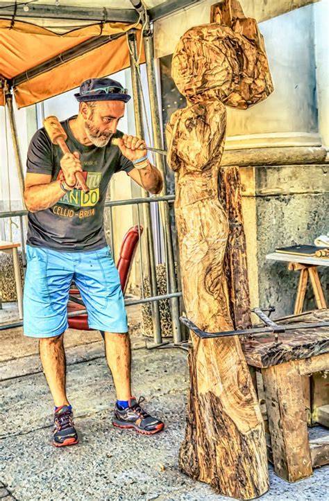 Scultore locale al lavoro su un pezzo di legno in Val Gardena.