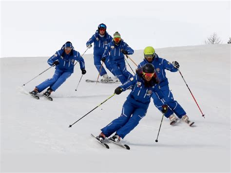 foto di un gruppo di maestri di sci che tengono una lezione su una pista innevata