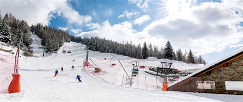 Panorama innevato della Valmalenco con piste da sci e montagne circostanti.