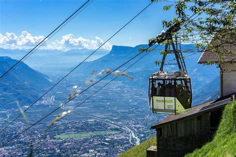 Immagine della Funivia dell'Alta Muta che sale verso le montagne, con vista sulla valle.