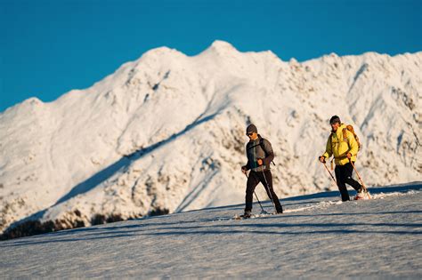 Coppia che cammina con le racchette da neve su un sentiero innevato in Val Bedretto